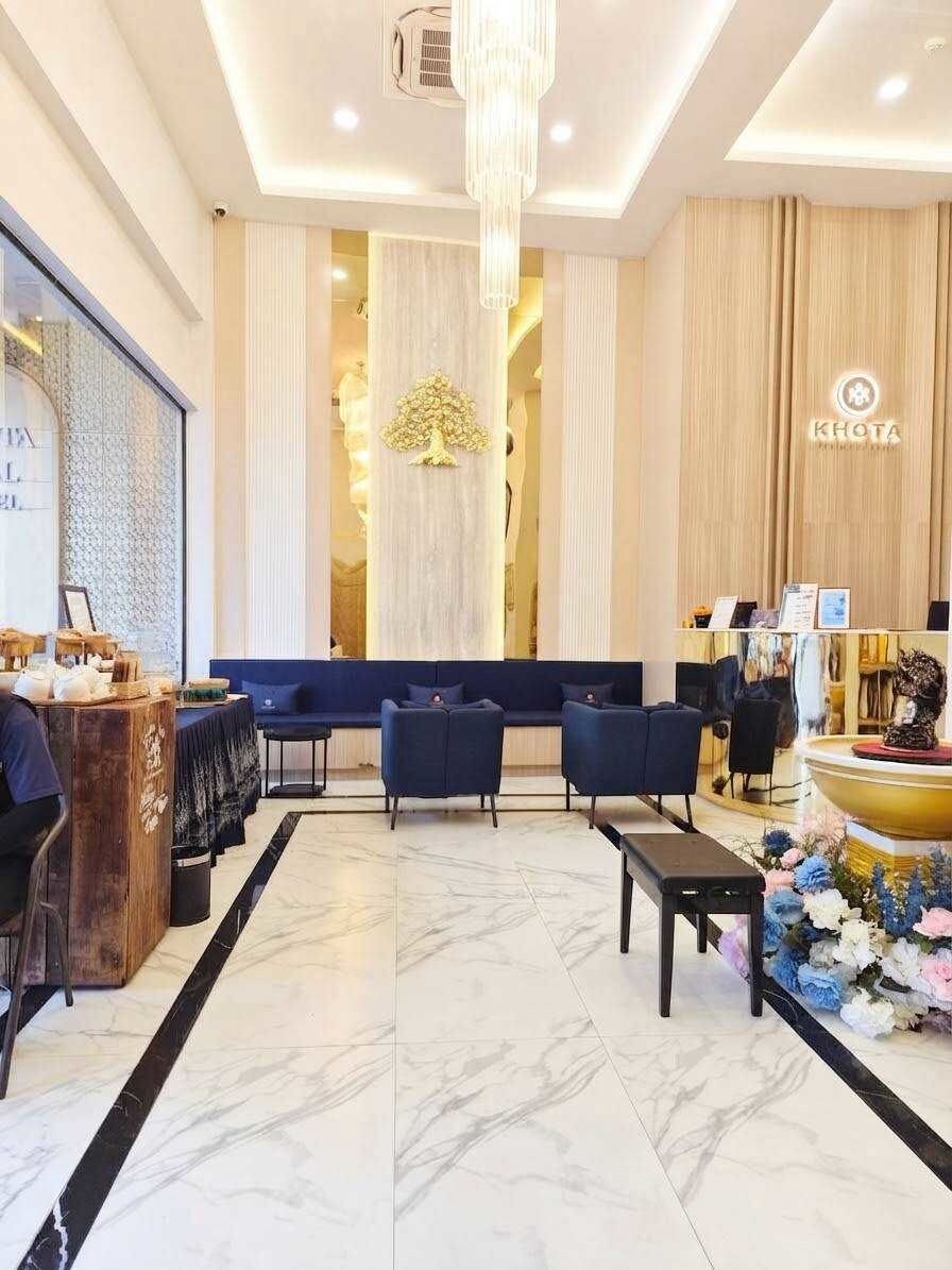 Un hall d’hôtel comprenant un comptoir d’accueil, un espace salon et une fontaine décorative.