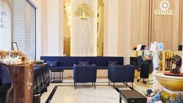 Un hall d’hôtel comprenant un comptoir d’accueil, un espace salon et une fontaine décorative.