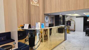 Un mostrador de recepción con un logotipo, una computadora y folletos informativos.