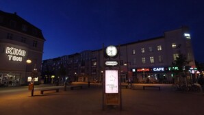 En plads med et ur, bænke og et skilt for Antonplatz.