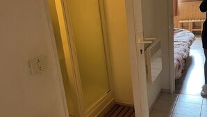 A room with a sliding door leading to a bedroom with a bed and a window.