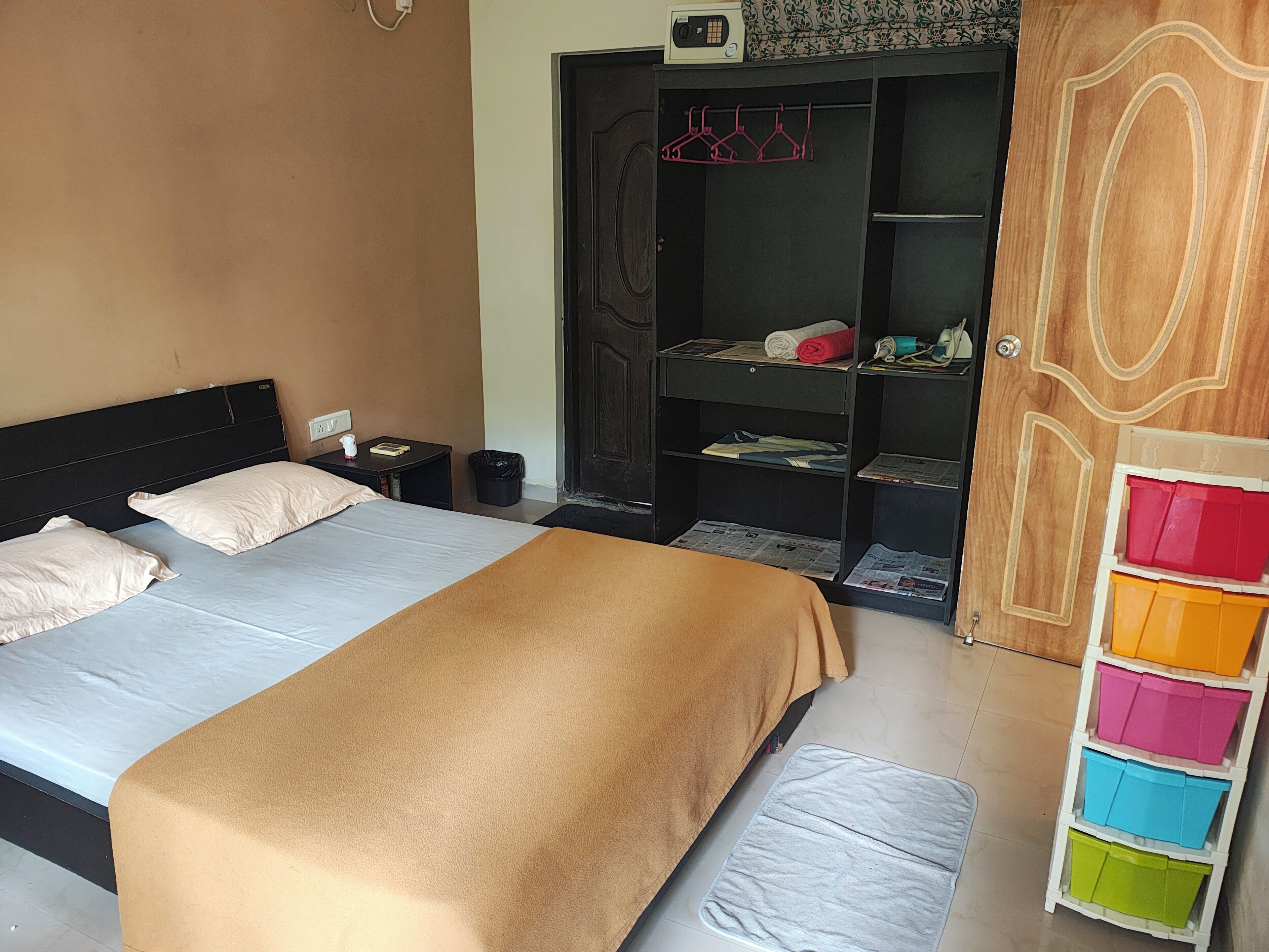 A bedroom with a bed, bedside table, and a wardrobe with shelves.