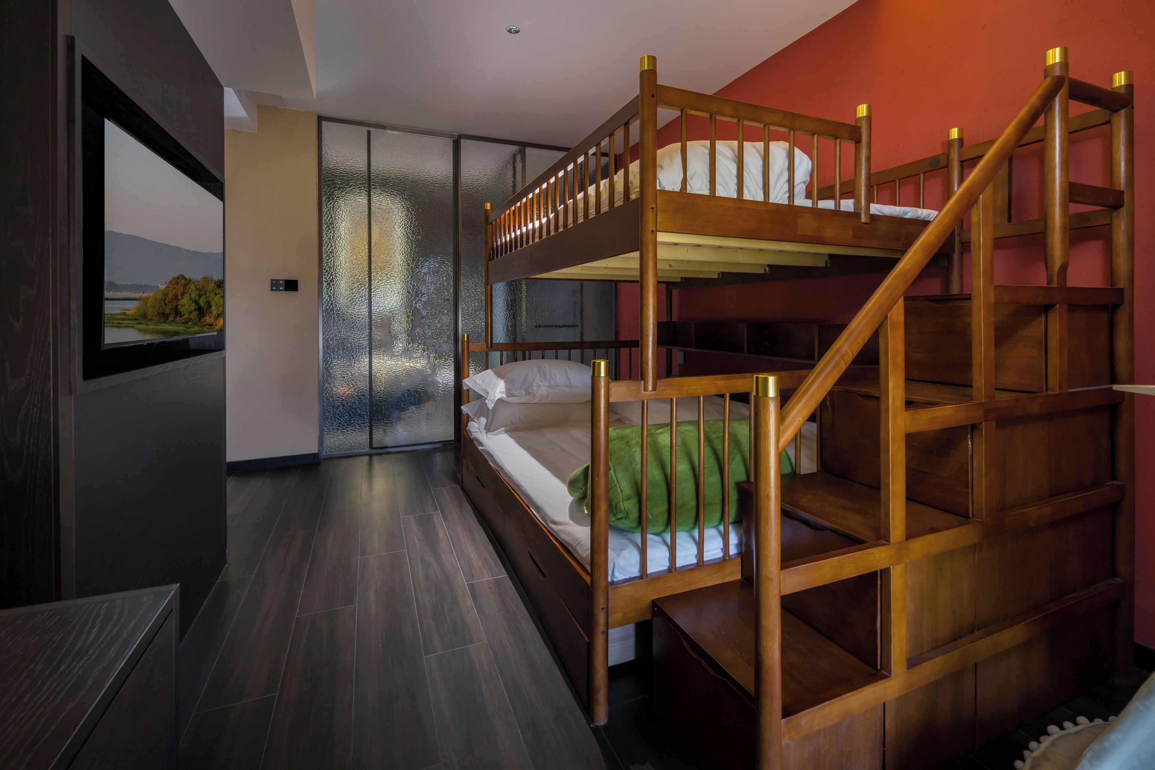 A bunk bed room with a view of a lake through a window.