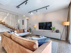 A modern living room with a sofa, coffee table, TV, and a staircase. - Stunning private villa for 8 people with A/C, private pool, WIFI, TV and terrace (Pazin)
