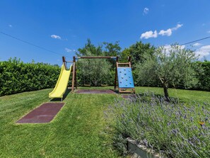 A playground with a yellow slide and a blue climbing structure.