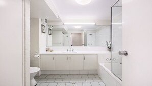 Ein modernes Badezimmer mit einem weißen Waschbecken, Spiegel und Dusche.