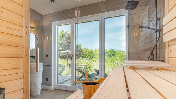 A modern bathroom with wooden paneling, a large mirror, and a glass shower enclosure.