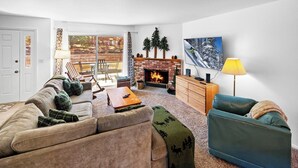 A living room with a fireplace, a sofa, a coffee table, and a TV.