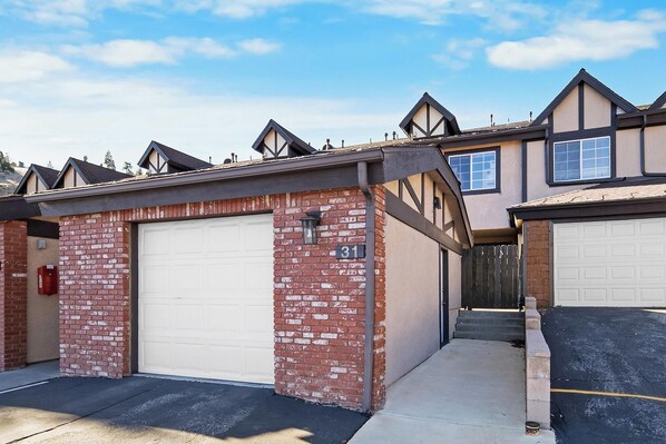 A residential building with a garage, brick facade, and a number '31' sign.