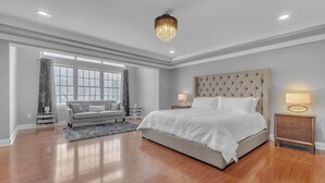 A spacious bedroom with a large bed, a sofa, and a chandelier. - Ellicottville Chalet & Cottage 5 Mi to Village (Salamanca)