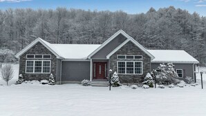 A two-story house with a red door, large windows, and a snow-covered landscape. - Ellicottville Chalet & Cottage 5 Mi to Village (Salamanca)