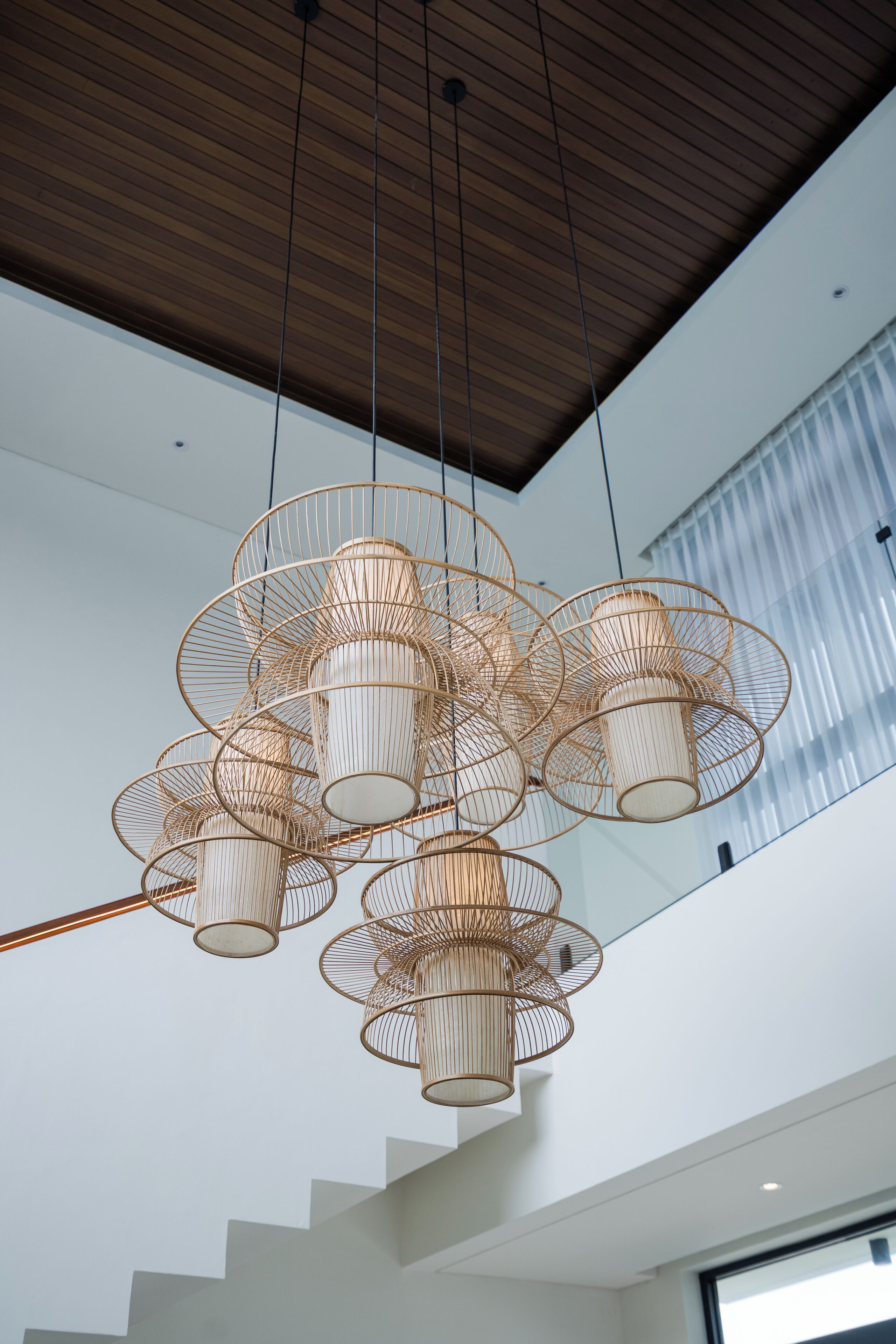 A modern interior with a unique ceiling light fixture and a staircase leading to an upper level.
