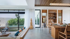 A modern interior with a dining area, seating, and a view of the outdoors. - Uma Namu Villa by Betterplace (Canggu)