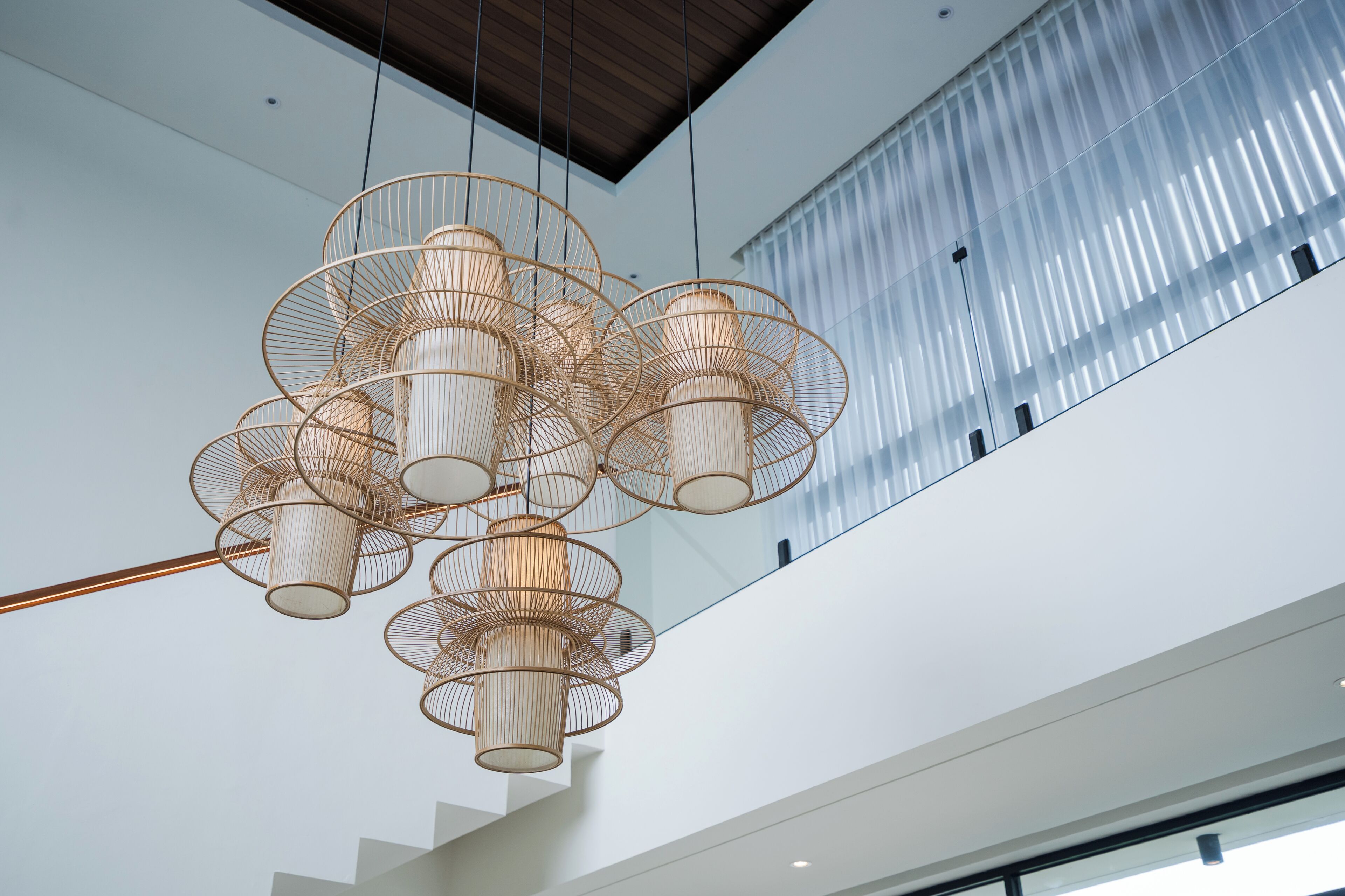 A modern interior with a unique hanging light fixture and a view of a building outside.