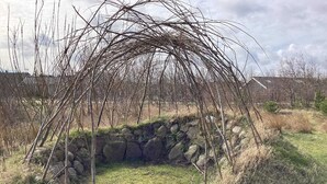 A stone wall with a natural archway formed by branches. - 5 Person Holiday Home in Brovst (Brovst)