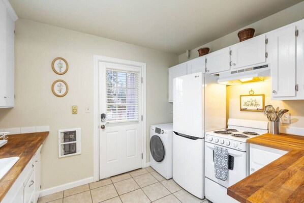 A compact kitchen with a washing machine, a refrigerator, and a stove.