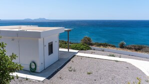 Une terrasse sur le toit offrant une vue dégagée sur la mer et les montagnes lointaines.