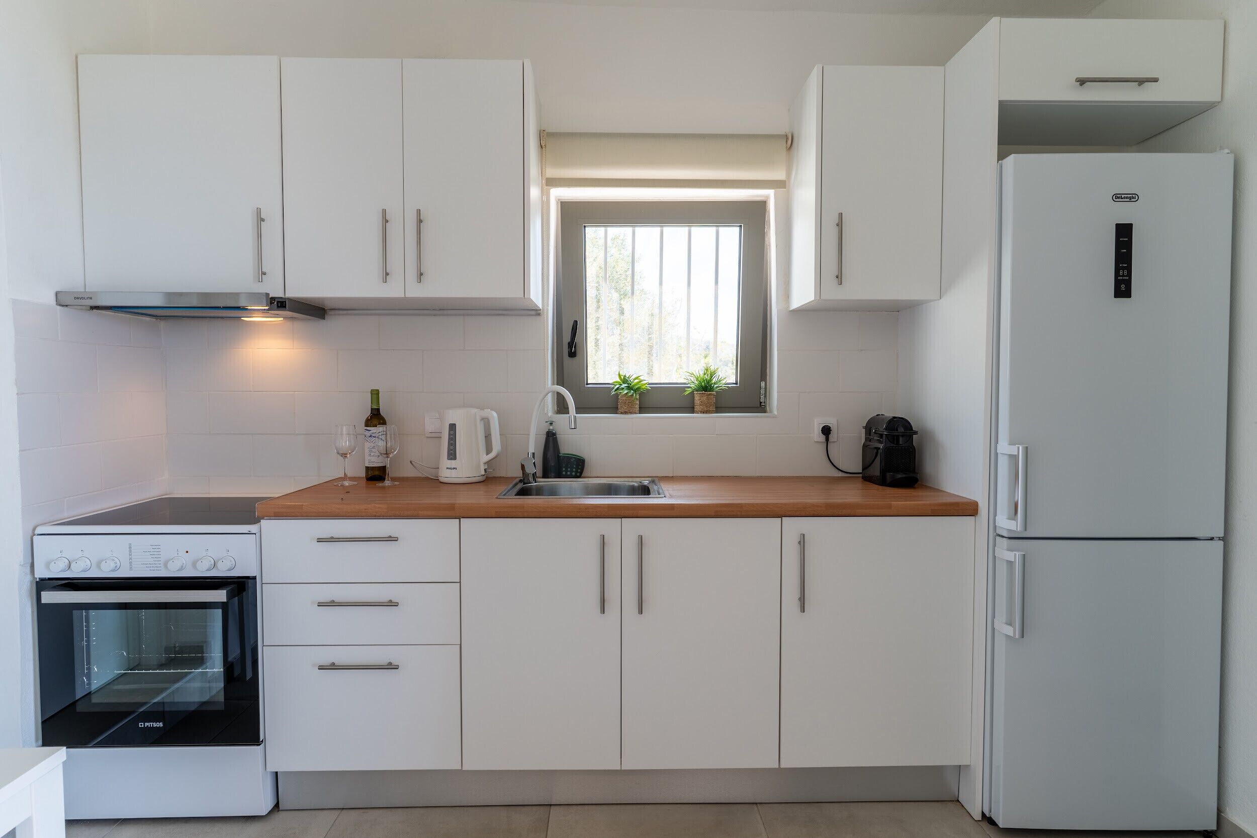 Een koelkast, een oven, een koffiezetapparaat/waterkoker, een waterkoker