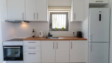 Een koelkast, een oven, een koffiezetapparaat/waterkoker, een waterkoker