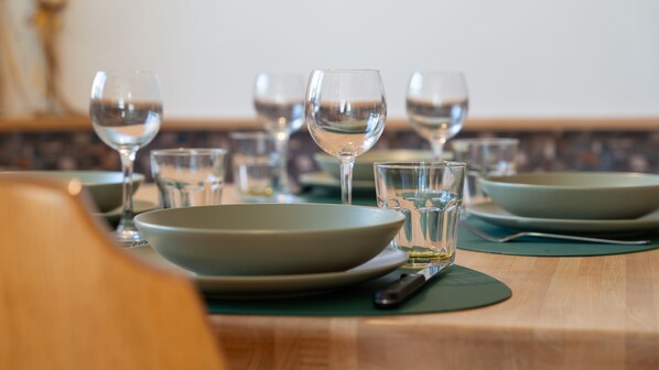 A dining table set with clear glassware and green plates, indicating a formal dining arrangement. - Milano 20 in Bormio With 1 Bedrooms and 1 Bathrooms (Bormio)