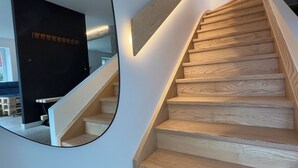 A modern staircase with wooden steps and a light-colored wall. - At 162 • Cosy 8-person house in the heart of the Vosges mountains (Anould)