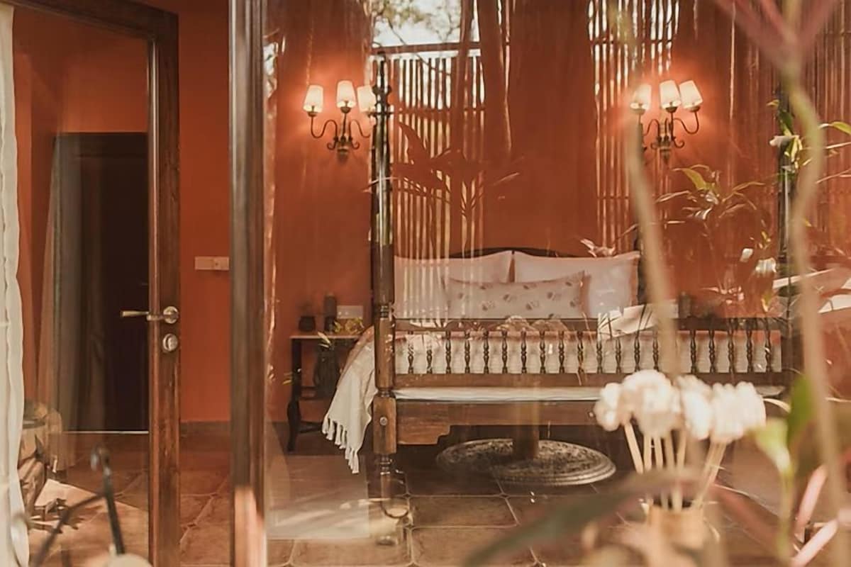 A bedroom with a bed, a nightstand, and a lamp.