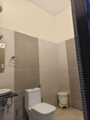 A bathroom with a toilet, bidet, and sink. - Holiday Highlight By Golden Castle Hotel (Ramnagar)