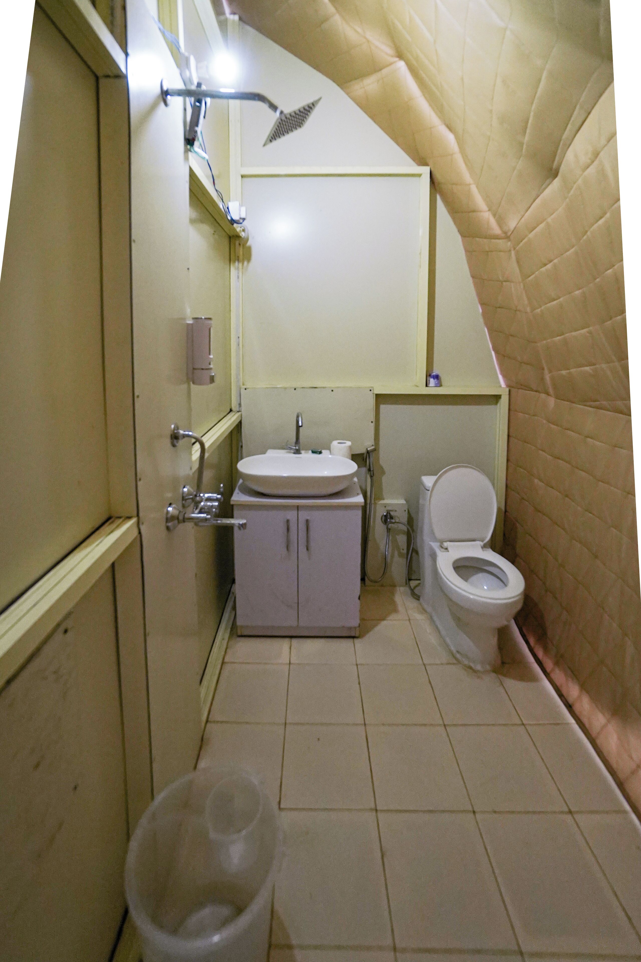 A compact bathroom with a toilet, sink, and shower.