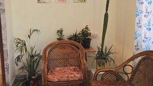 Une pièce chaleureuse, meublée de meubles en osier, avec une petite table et des plantes en pot.