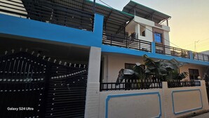 Un bâtiment à deux étages, doté d’une façade bleue et blanche, d’une entrée fermée par un portail et d’une enseigne indiquant « RAC Tyres ».