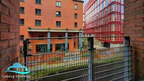 Un immeuble à plusieurs étages, doté d’une façade en briques et d’une couleur rouge.