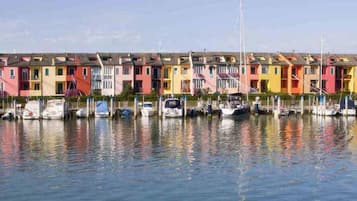 Un conjunto de casas coloridas junto a un muelle tranquilo, con barcos amarrados.