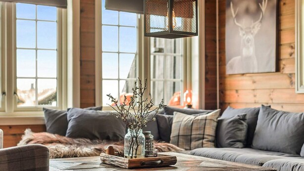 A cozy living room with a wooden coffee table, a sofa, and a decorative vase with branches. - 9 Person Holiday Home in Rauland (Vinje)