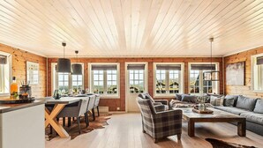 A spacious living area with a wooden ceiling, a dining table set, and a sofa. - 9 Person Holiday Home in Rauland (Vinje)
