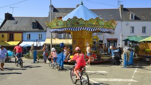 A carousel in a public square with people riding bicycles around it. - Apartment with private garden and modern amenities (Groix)