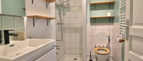 A bathroom with a shower, toilet, and sink.