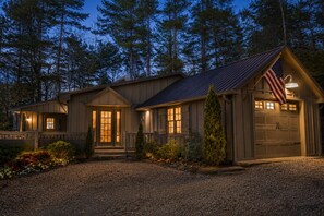 Une maison à deux étages avec un porche à l’avant, un garage et un drapeau.
