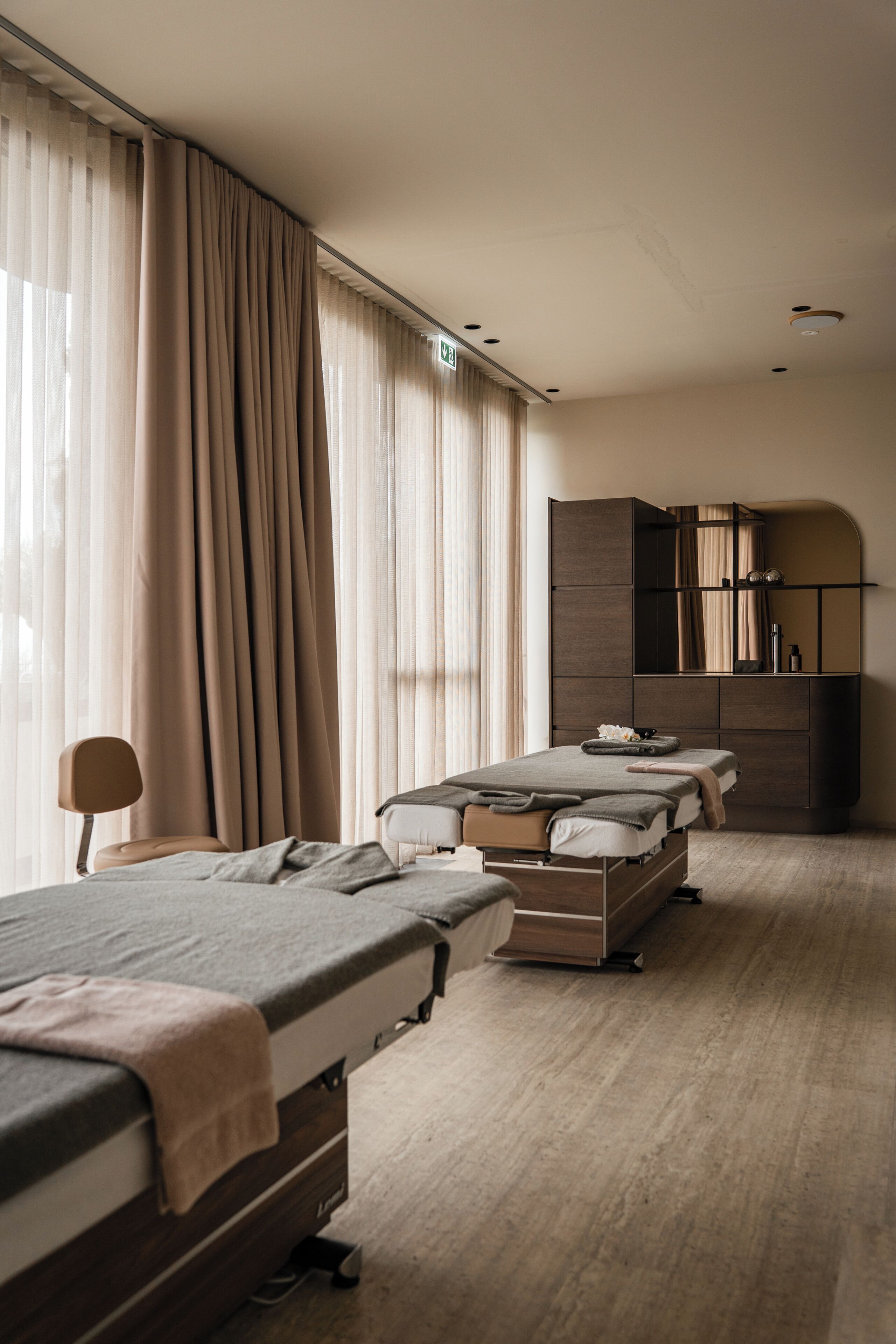 Habitación de hotel con dos camas individuales, sofá cama, escritorio y armario.