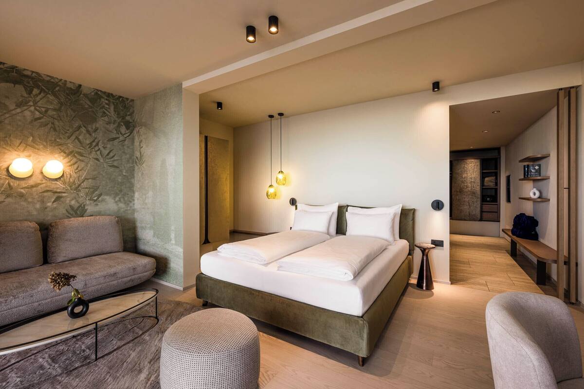 A modern bedroom with a large bed, a sofa, and a coffee table.