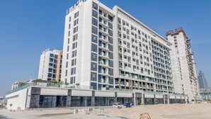 Et moderne hotel med flere etager, der har en markant indgang og en stor parkeringsplads.