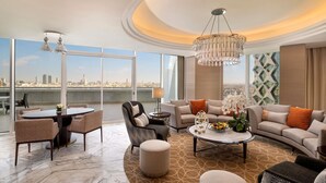 A spacious living room with a city view, a chandelier, and modern furnishings.