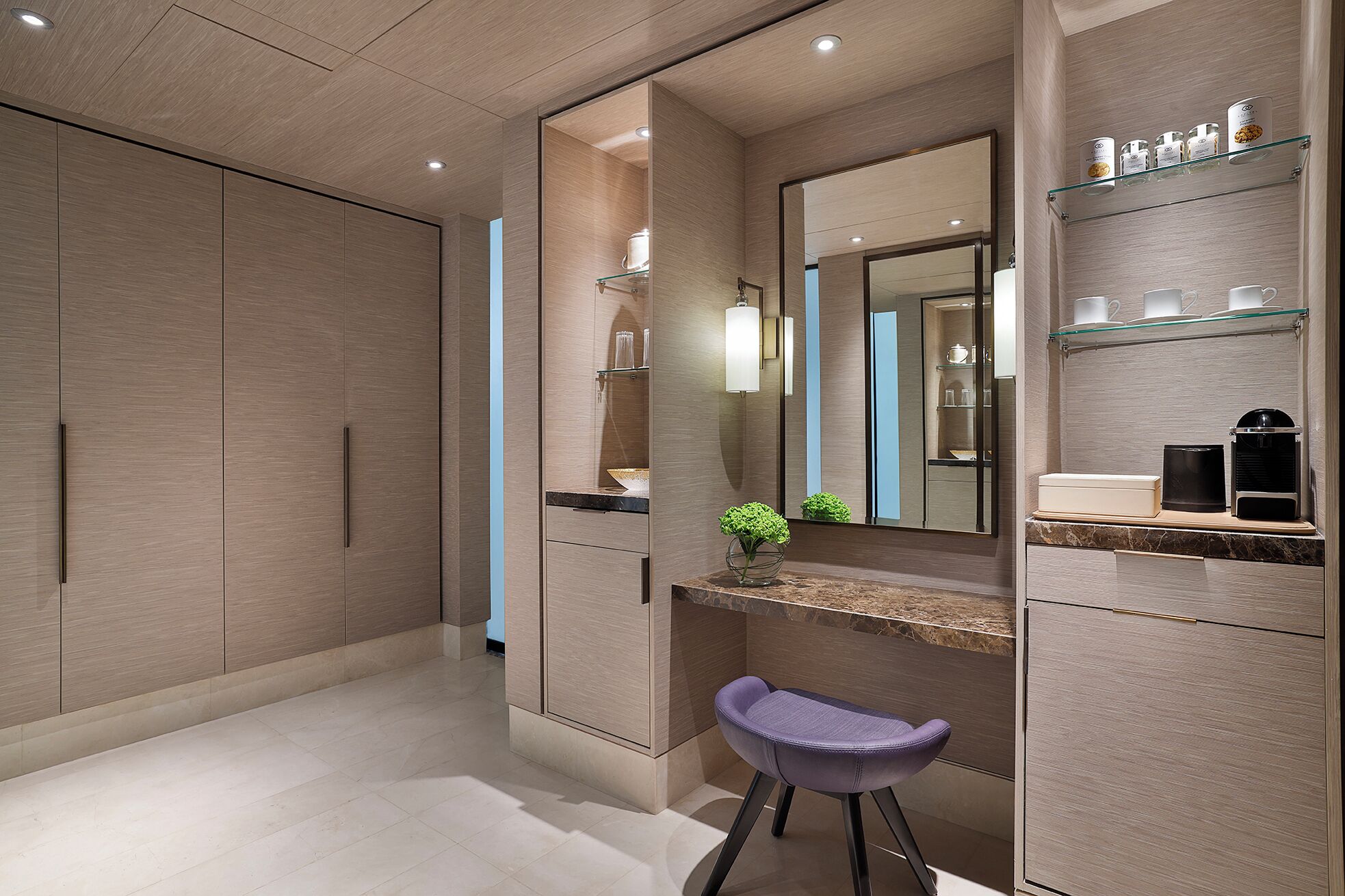 A modern bathroom with a vanity, mirror, and shelves with toiletries.