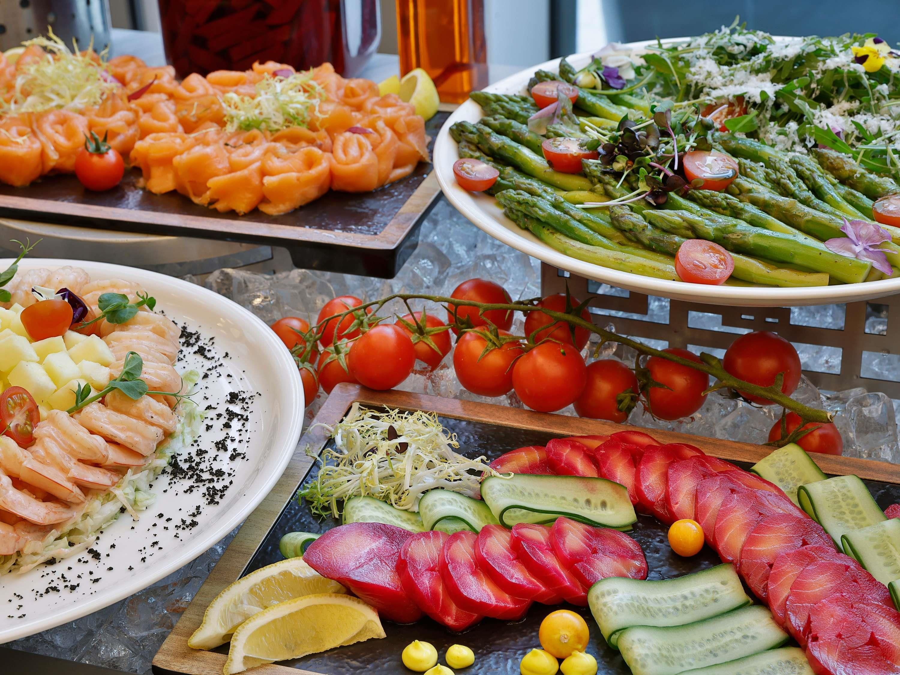 A variety of food items on a table, including seafood, vegetables, and salads.