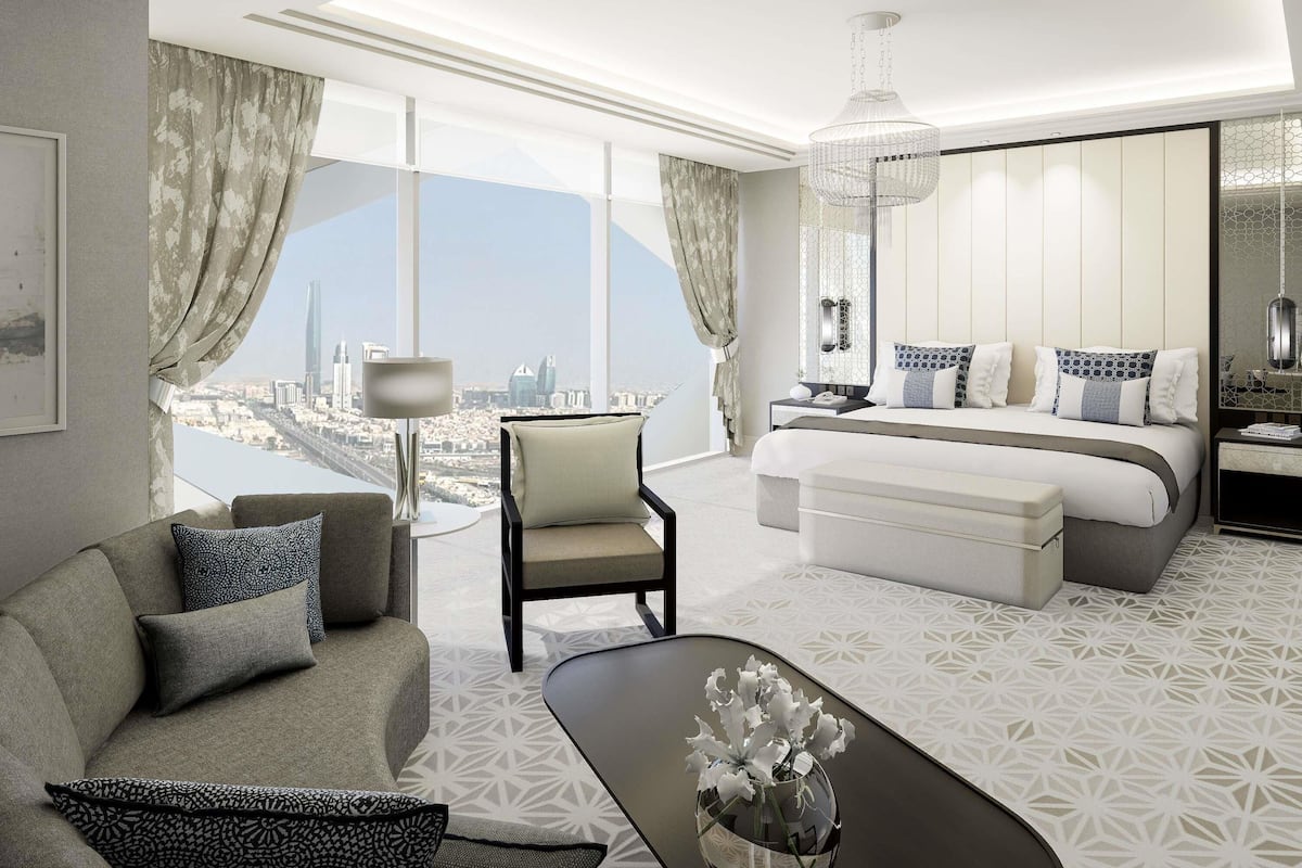 Ein modernes Hotelzimmer mit Blick auf die Stadt, einem großen Bett, einer Couch, einem Schreibtisch und einer Chandelüstere.