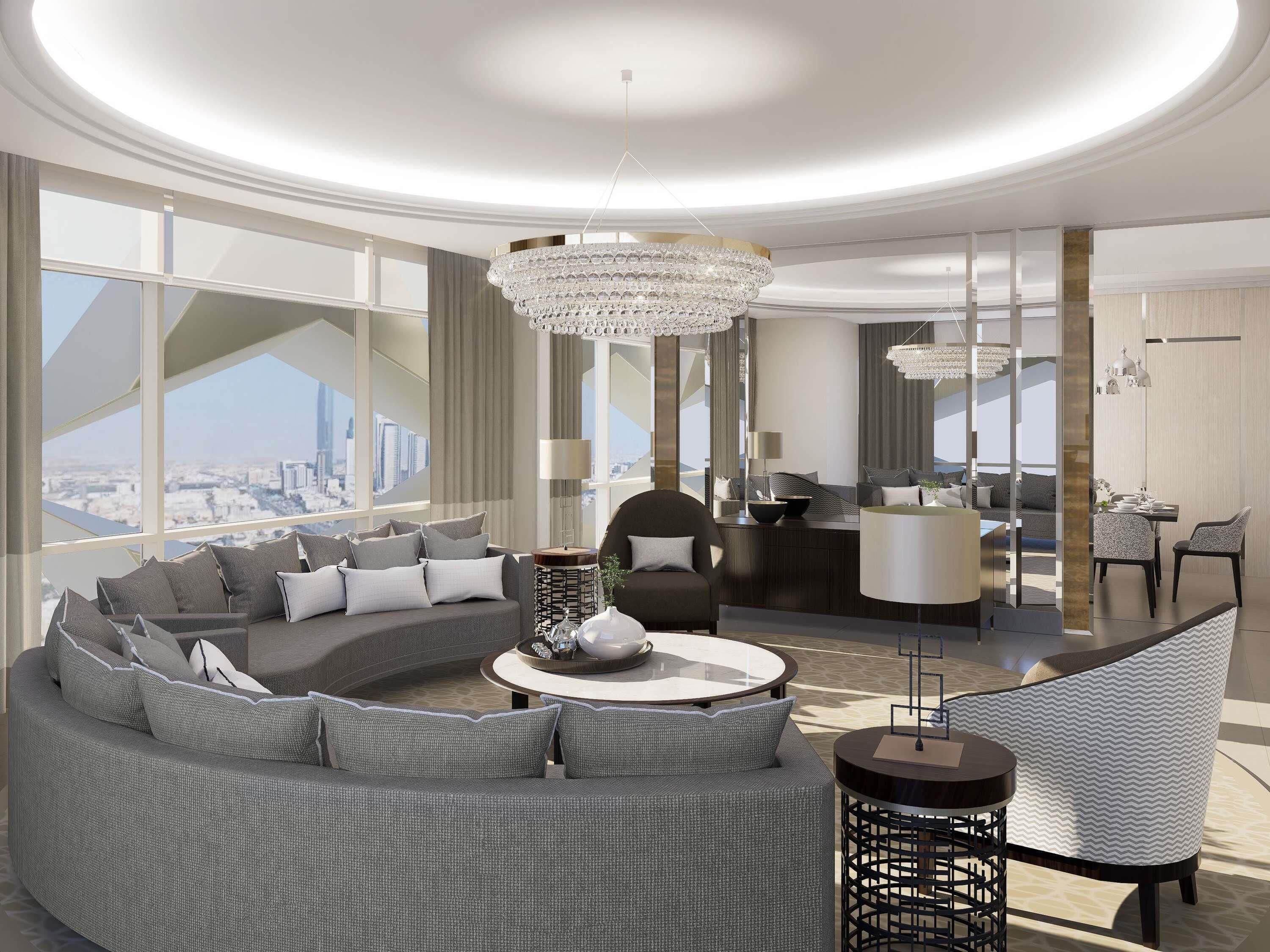A modern living room with a curved sofa, a round coffee table, and a dining area with chairs and a table.