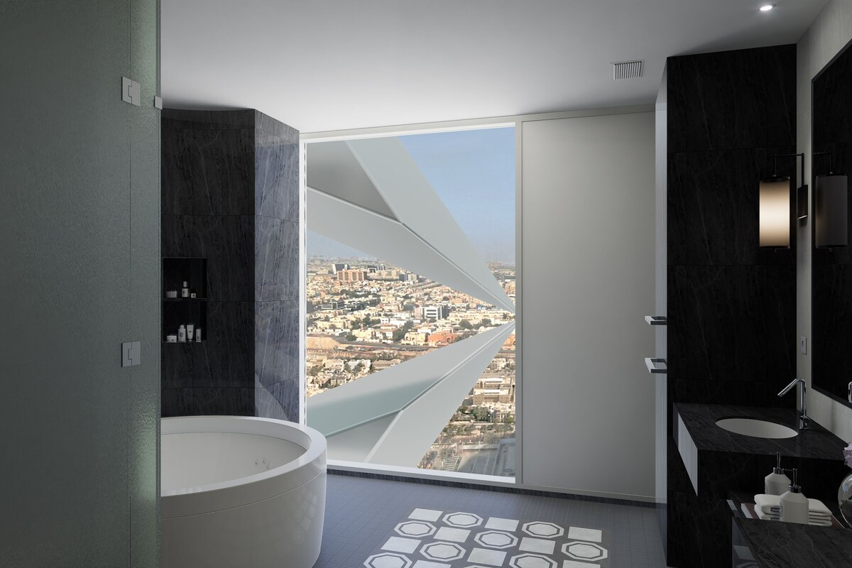 A modern bathroom with a large bathtub, a vanity with a sink, and a view of a cityscape through a large window.