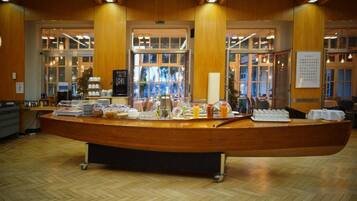 A reception area with a wooden reception desk, a glass display case, and a view of the outside through large windows.