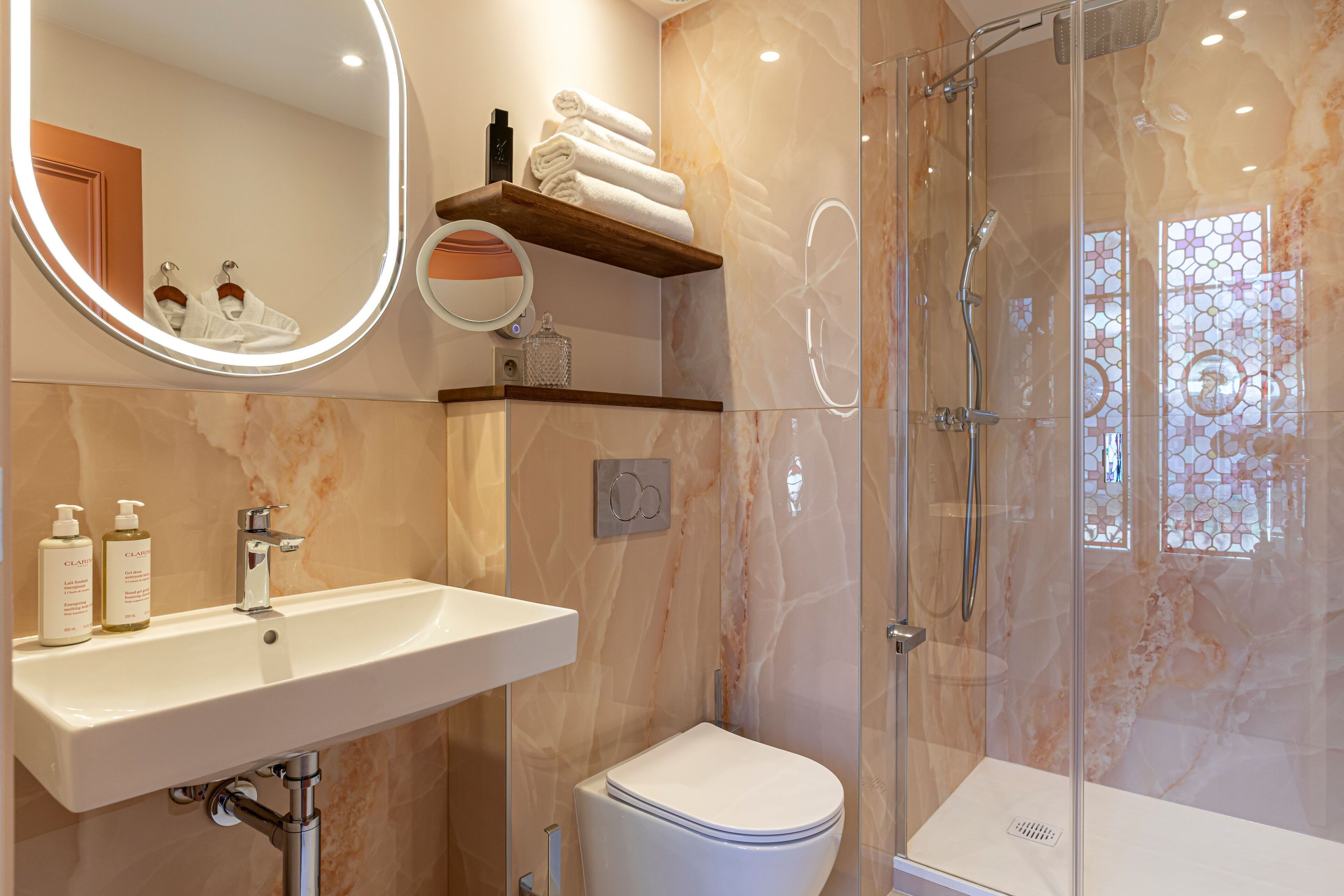 Et moderne badeværelse med vask, toilet og glasbrusekabine.