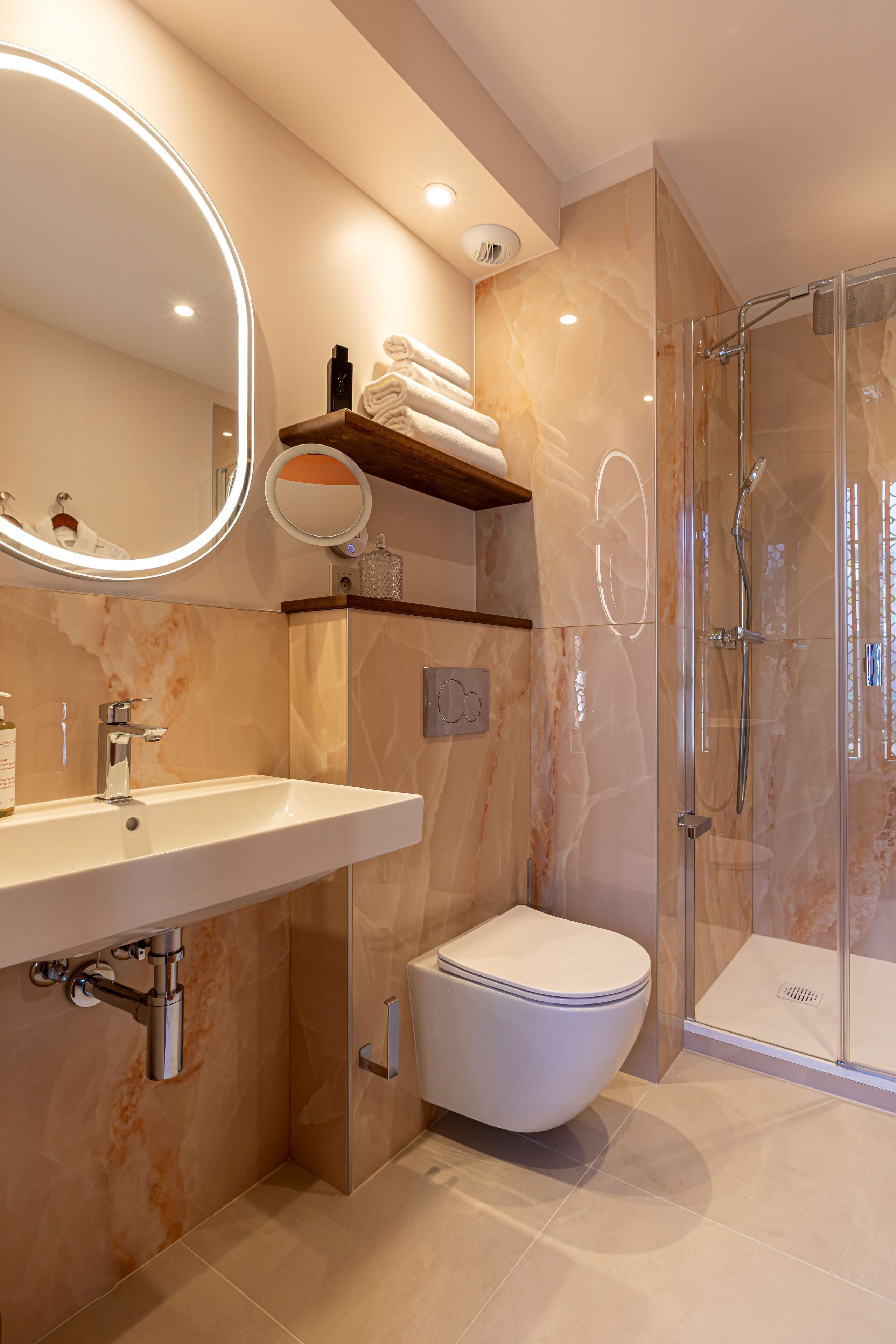 A modern bathroom with a sink, toilet, and glass-enclosed shower.