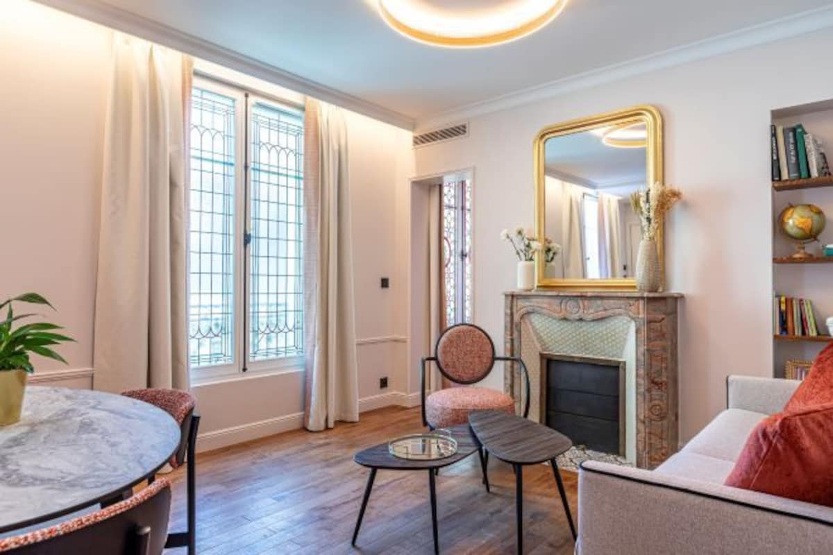 A living room with a fireplace, a round table, and a sofa.